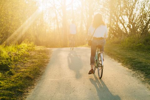 Zwei Fahrradfahrer fahren in den Sonnenuntergang