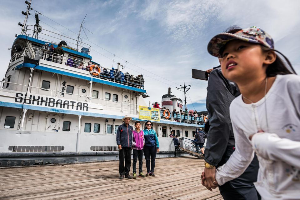 Beliebtes Fotomotiv: Touristen porträtieren vor dem Schiff "Sukhbaatar" in Chatgalam am Südufer des Chöwsgöl-Sees in der Mongolei