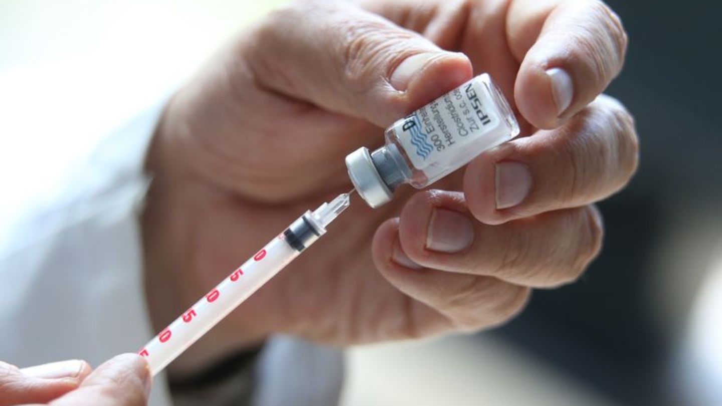 Arzt zieht mit einer Spritze den Botox-Stoff aus einem kleinen Gefäß