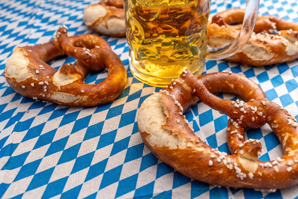 Salzbrezeln und Bier auf einer blauweißen Tischdecke  1.5004