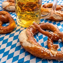 Salzbrezeln und Bier auf einer blauweißen Tischdecke