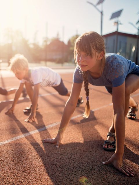 Kinder starten zu einem Wettlauf auf der Tartanbahn