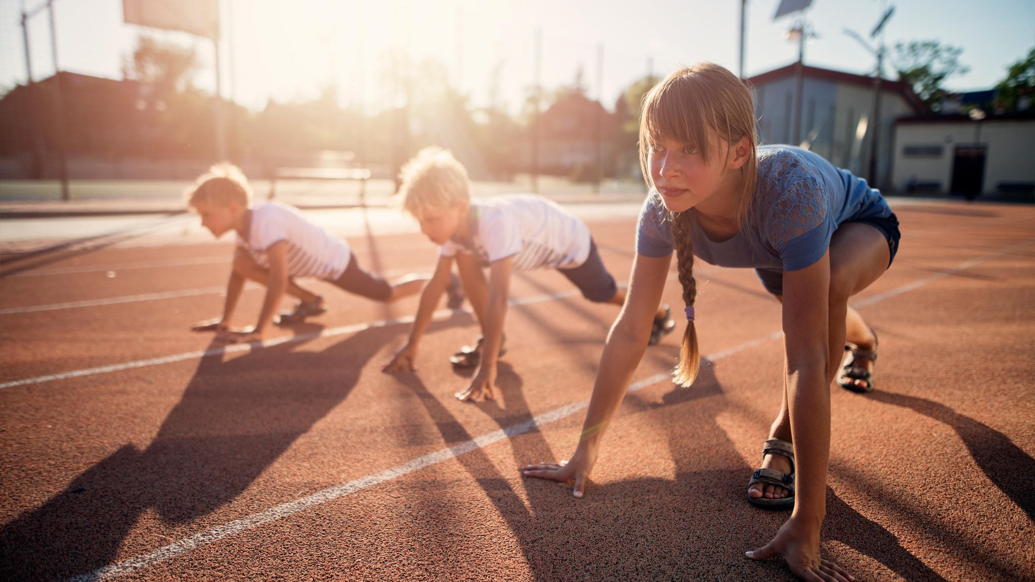 Kinder starten zu einem Wettlauf auf der Tartanbahn