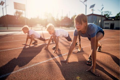 Kinder starten zu einem Wettlauf auf der Tartanbahn