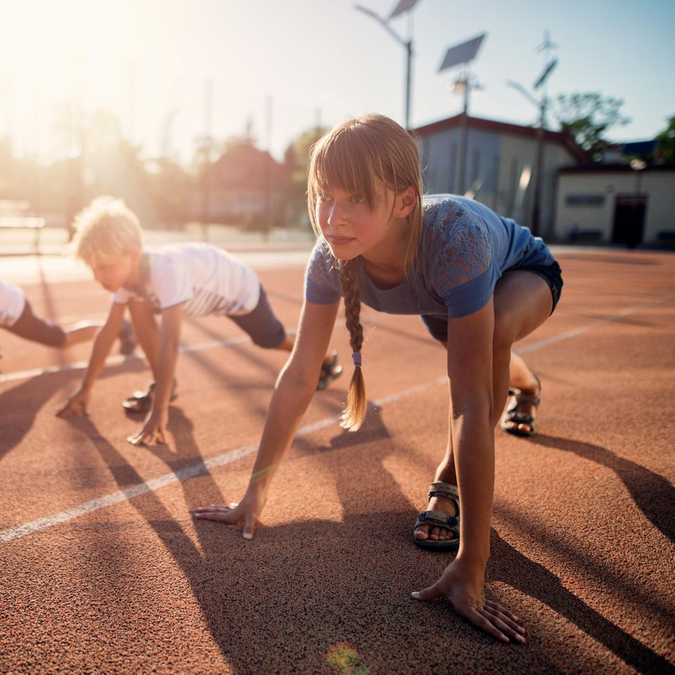 Kinder starten zu einem Wettlauf auf der Tartanbahn