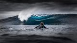 In Westaustralien fotografierte Jarvis Smallman diesen Surfer und eine sich brechende, blau schimmernde Welle, während Regenwolken aufziehen: erster Platz in der Kategorie Young Ocean Photographer of the Year