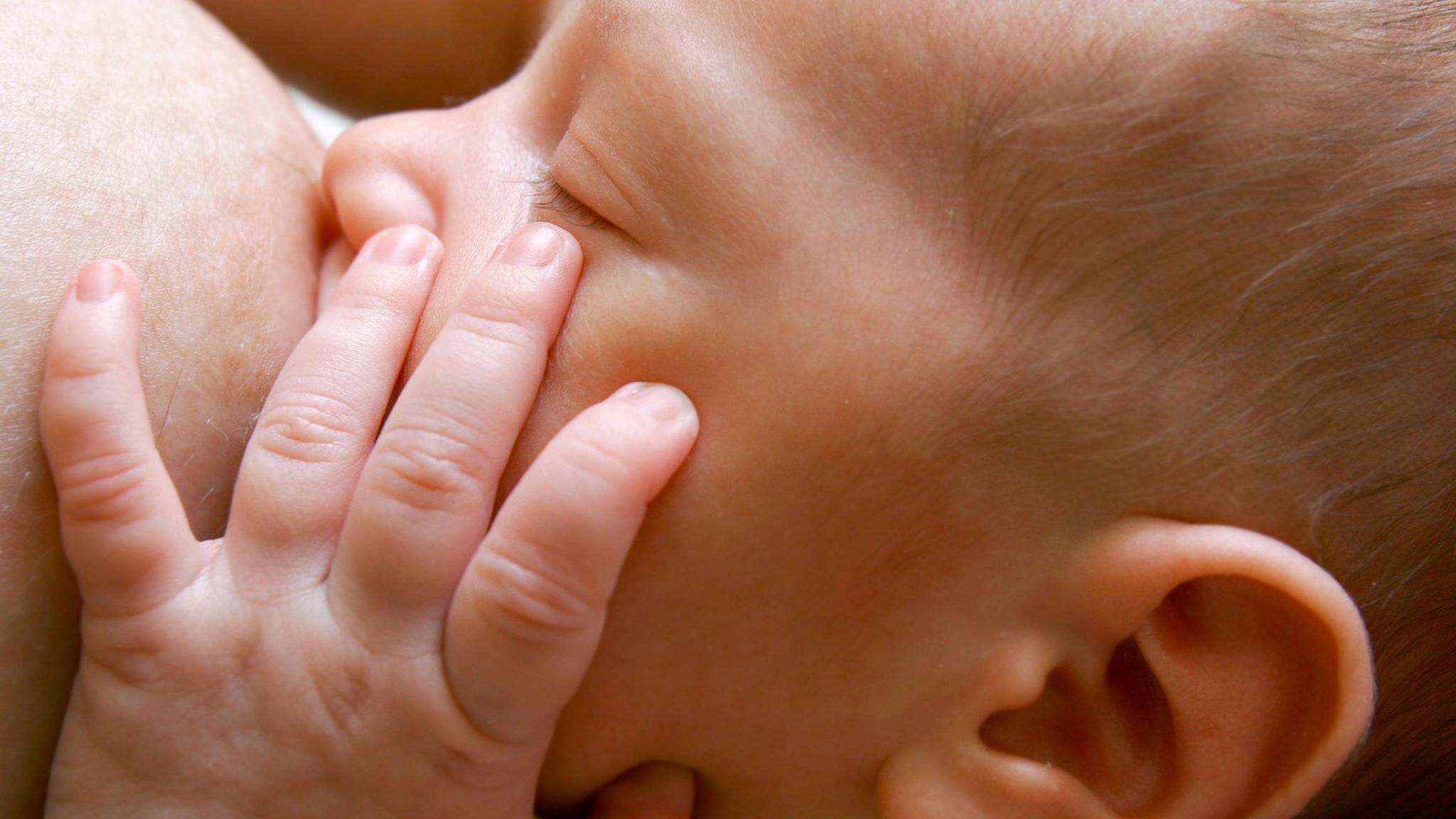 Ein Baby trinkt von der Brust seiner Mutter