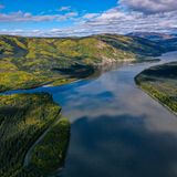Fluss schlängelt sich durch hügelige Landschaft