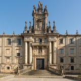 Eine große Freitreppe führt auf eine Tür eines dreistöckigen Hauses zu. Eine Figurengruppe ist auf dem Dach.