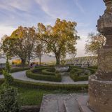 Barockgarten mit Wegerundkurs, Buchsbäumchen, Bäumen und Brunnen.