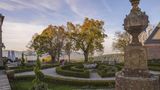 Barockgarten mit Wegerundkurs, Buchsbäumchen, Bäumen und Brunnen.