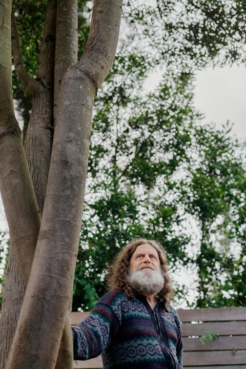 Neurowissenschaftler Robert M. Sapolsky steht leicht angelehnt an einem Baum.