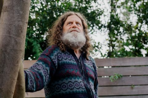 Neurowissenschaftler Robert M. Sapolsky steht leicht angelehnt an einem Baum.