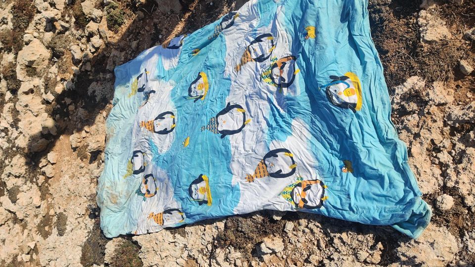 Pinguindecke liegt am Strand von Lampedusa