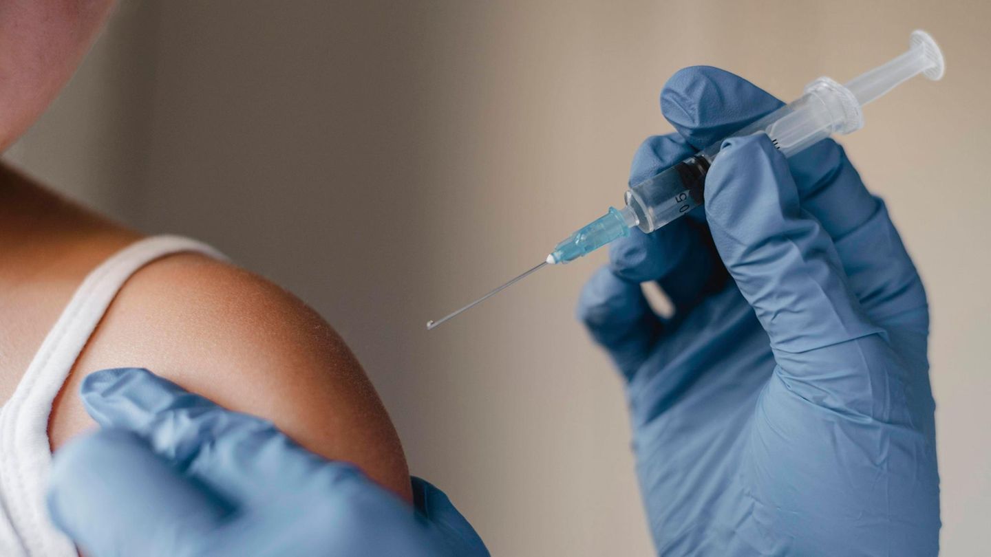 Ein Arzt impft ein Kind gegen die Grippe Ein Arzt impft ein Kind gegen die Grippe