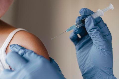 Ein Arzt impft ein Kind gegen die Grippe