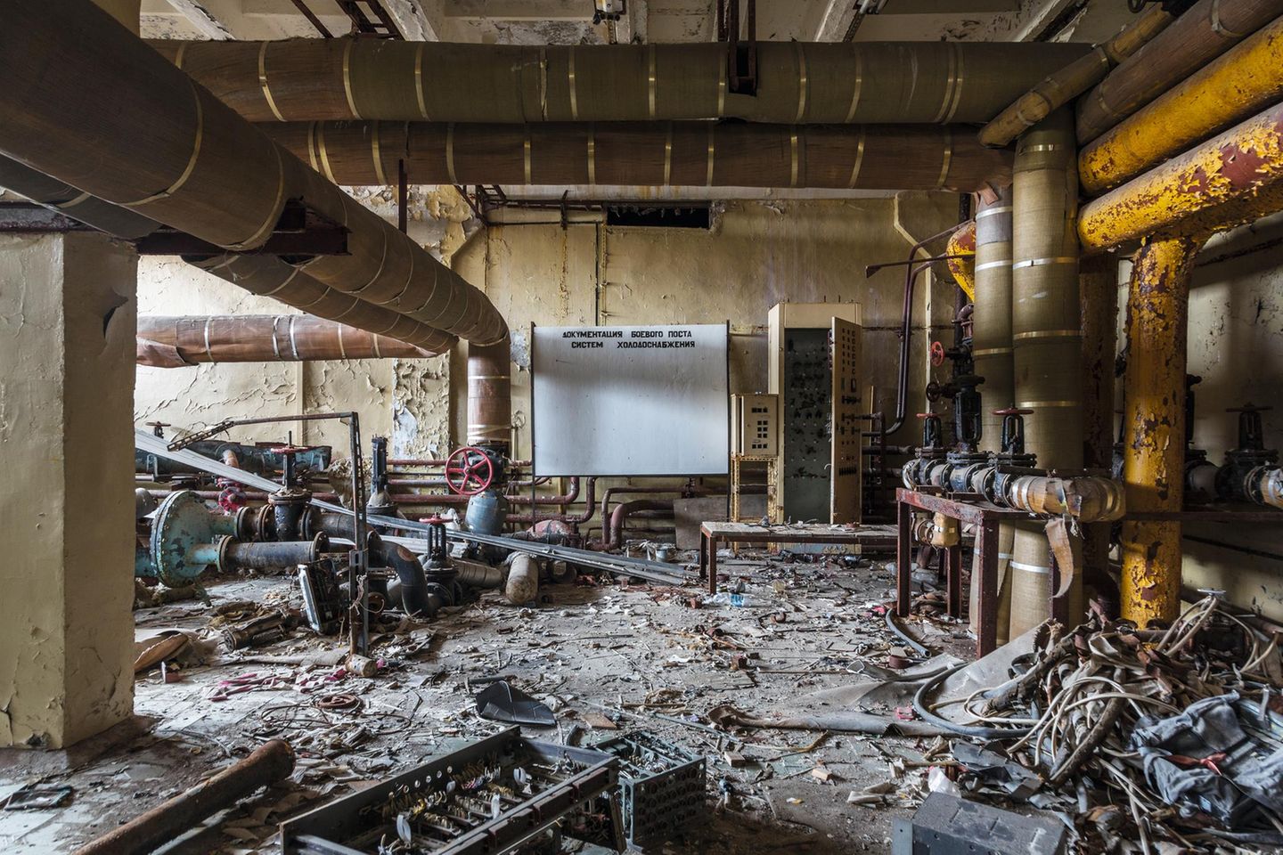 Verwahrlostes Rohrlabyrinth Rohre mit Steuerrad, Müll und Unrat auf dem Boden.