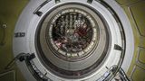 Kreisrunde Schleuse im Inneren einer Raumfähre, um die Luke sind Griffe für die schwebenden Kosmonauten.