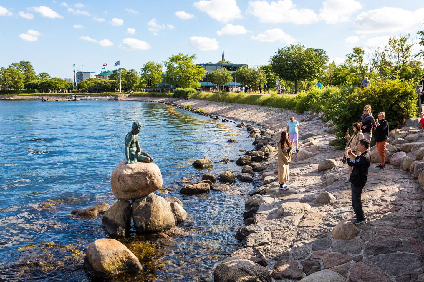 Die Kleine Meerjungfrau (dänisch: Den lille Havfrue) an der Uferpromenade Langelinie in Kopenhagen. Ein beliebtes Fotomotiv von Touristen.
