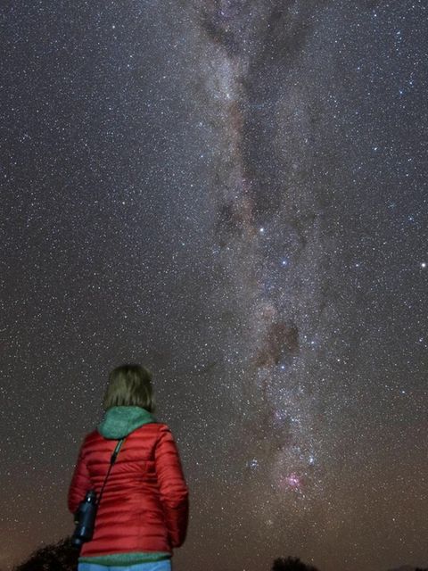 Frau schaut in den nächtlichen Sternenhimmel