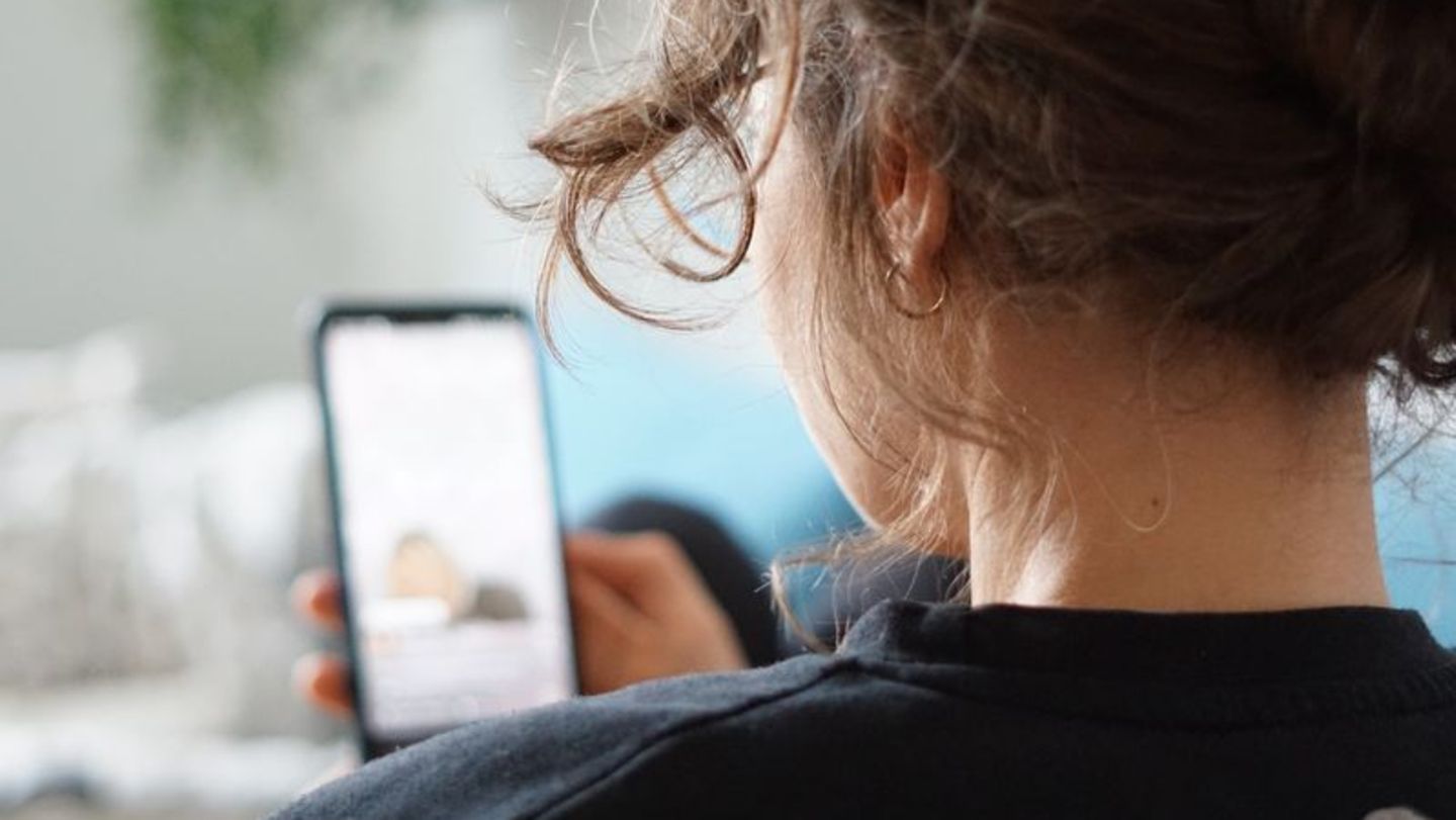 Eine Frau schaut auf Ihr Smartphone