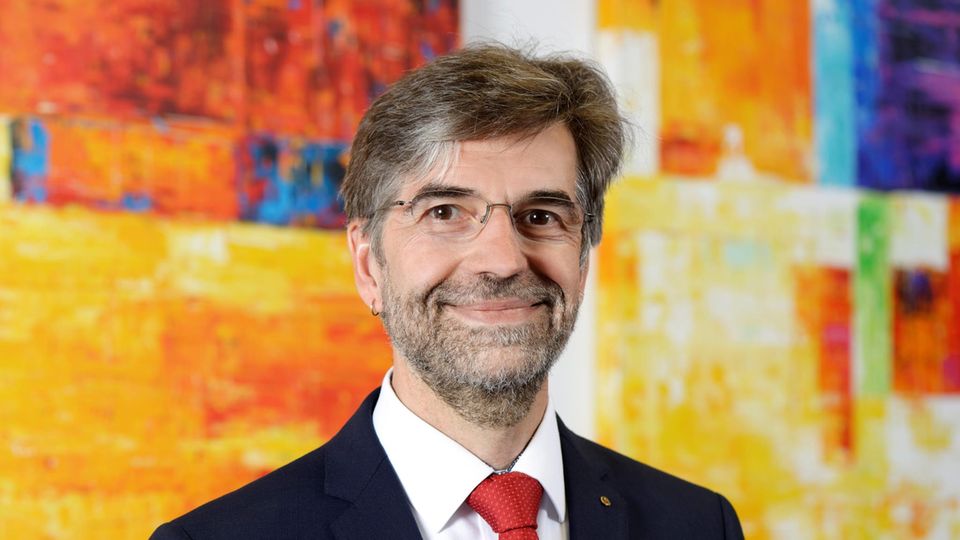 Thomas Niehr vor einem bunten Hintergrund