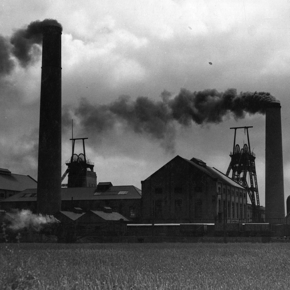 Rauch steigt aus den Schornsteinen eines Kohlebergwerks auf. Ca. 1950