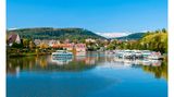 Ein Boot fährt über einen Fluss am Städtchen Saverne