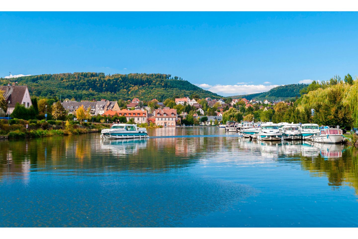 Das Elsass per Boot erkunden Ein Boot fährt über einen Fluss am Städtchen Saverne