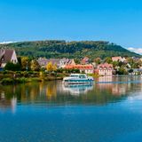Ein Boot fährt über einen Fluss am Städtchen Saverne