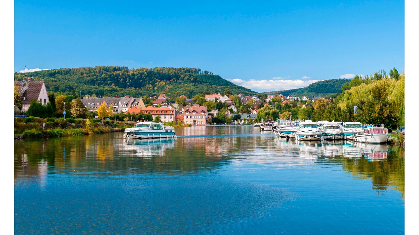 Das Elsass per Boot erkunden Ein Boot fährt über einen Fluss am Städtchen Saverne