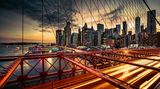 In der Abenddämmerung entsteht ein geometrisches Muster aus kantigen Gebäuden, Brückenstreben und den Gitternetzen der berühmten Hängebrücke über den East River. Die Lichter der vorbeiziehenden Autos verwandeln sich in Lichtstreifen. Rund 120.000 Fahrzeuge queren das Bauwerk täglich