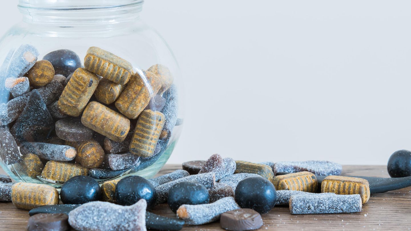 Salzlakritz in einem Glas udn auf einem Tisch verstreut