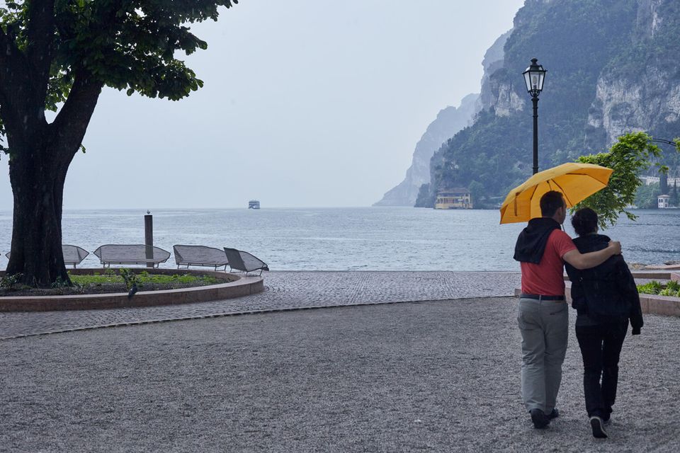 Paar spaziert bei Regen am Gardasee