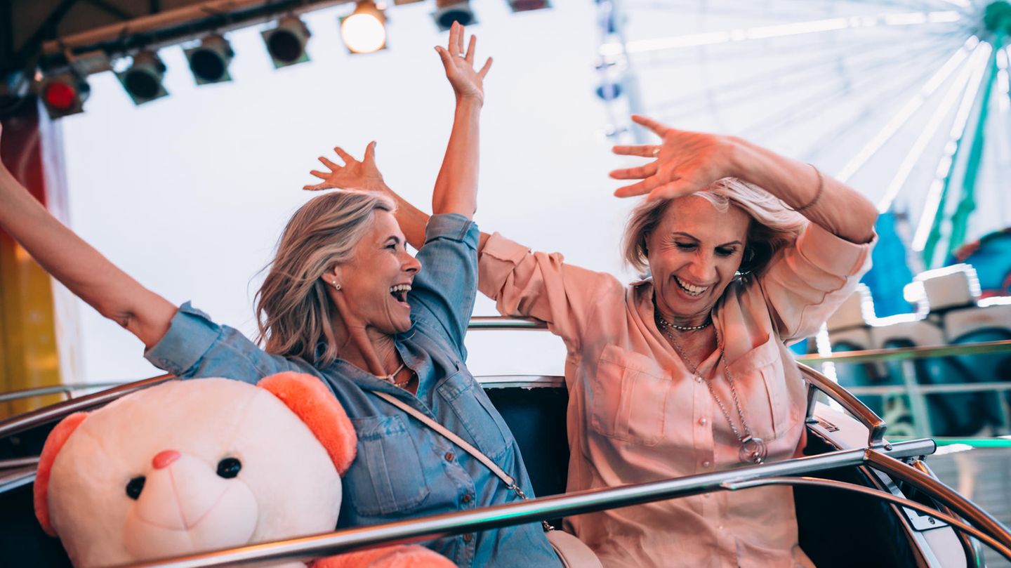 Zwei lachende und glückliche Frauen in der Achterbahn