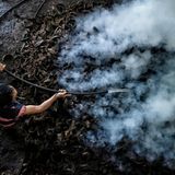 Salzsieder gießt Wasser auf dampfende Kokosnussschalen