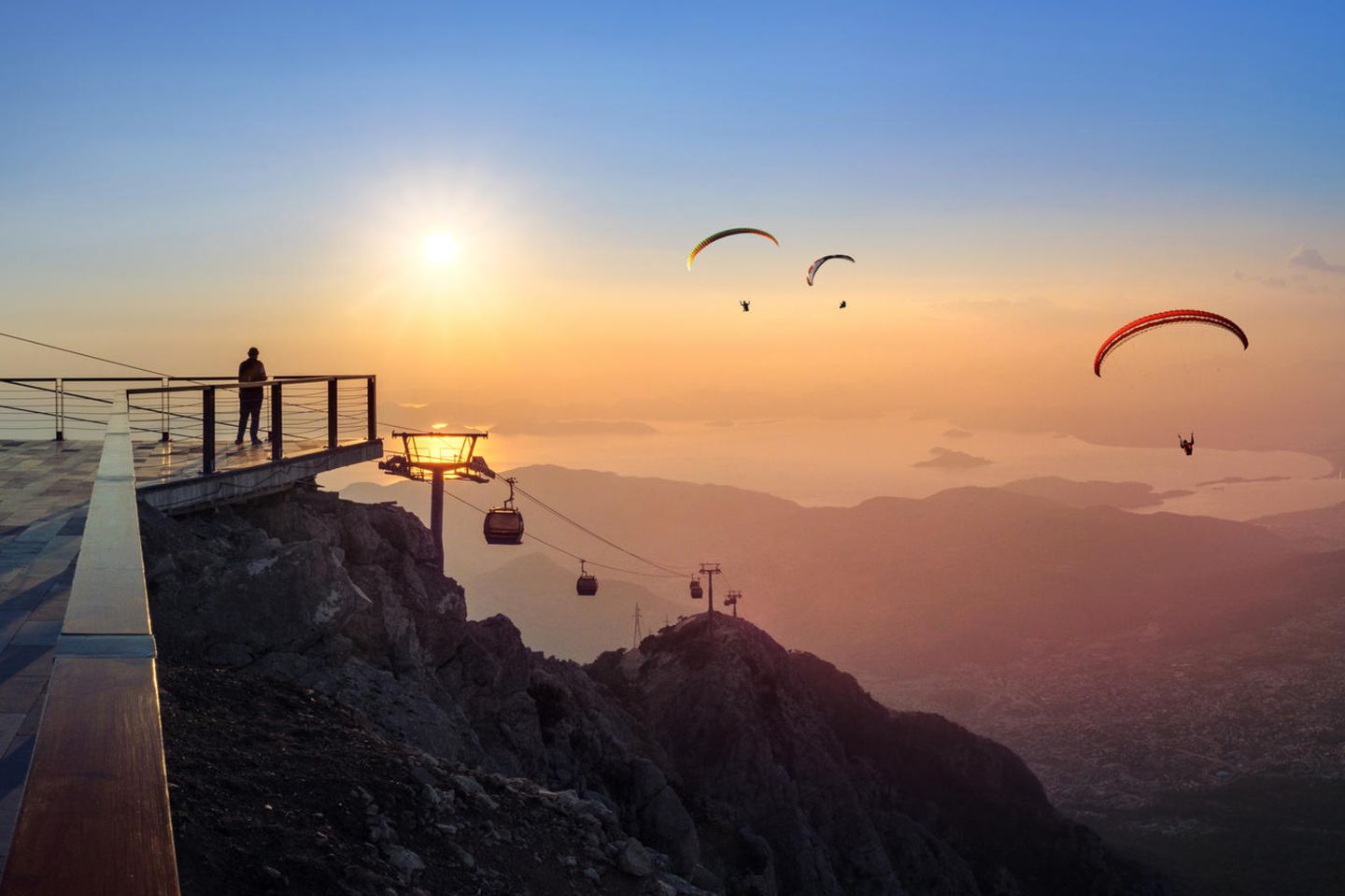 Babadağ – Gleitschirmfliegen über der Blauen Lagune Blick von einem Berg aus auf Paraglider in Abendstimmung