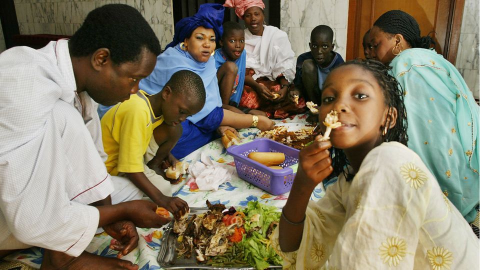 Essen mit der Hand eine Familie beim Essen mit der Hand und auf dem Boden