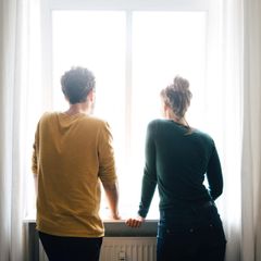 Junges Paar schaut aus dem Fenster