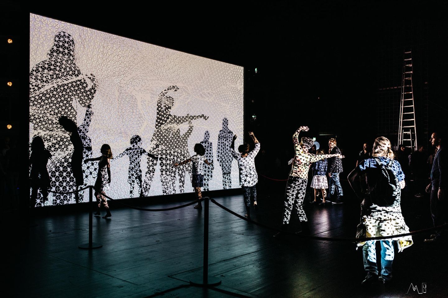 Theater für alle: Klanglicht in Graz Tanzende Menschen in einem Raum, projiziert auf eine beleuchtete Leinwand