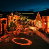 eine Gasse aus schwedischen Holzhäuser mit Holzsstühlen vor der Tür, bei Nacht, rot beleuchtet