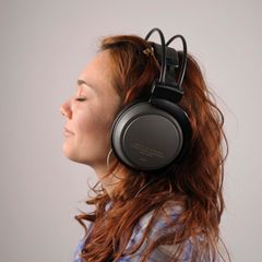 Junge Frau mit roten Haaren mit Kopfhörern