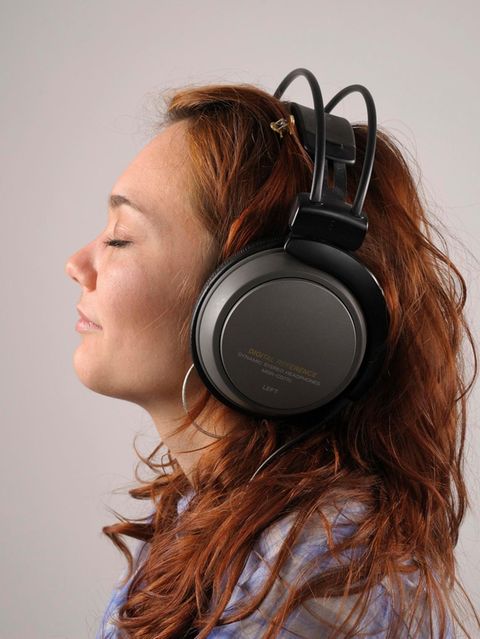 Junge Frau mit roten Haaren mit Kopfhörern