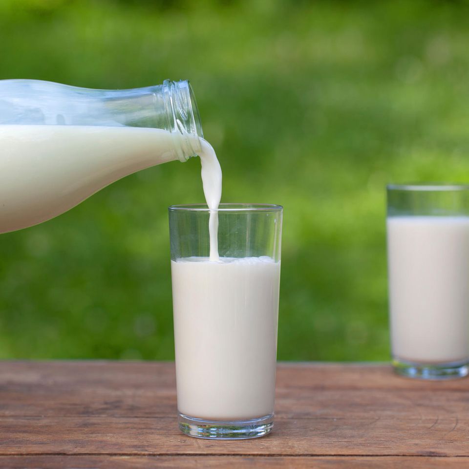 Milch wird aus einer Flasche in ein Glas gegossen. Ein zweites Glas steht daneben