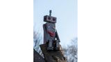 Auf einem Baumstumpf sitzt ein selbst gebastelter Roboter.