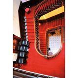 Blick von oben ins Treppenhaus, man sieht vor allem den roten Teppich auf der alten Treppe.