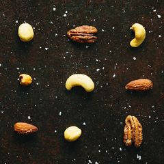 Verschiedene, mit Salz bestreute Nüsse liegen einzeln auf einem Blech