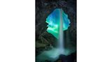 Von einer isländischen Höhle aus, mit Blickrichtung Süden, fotografierte der französische Fotograf Josselin Cornou ein Nordlicht. Ein seltener Moment, denn das Phänomen zeigt sich in der Regel in der entgegengesetzten Himmelsrichtung. Zusätzliche Dynamik erhält das Bild durch einen das Bild teilenden Wasserfall