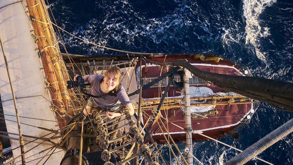 Verena Brüning klettert auf den Mast des Traditionsseglers "Roald Amundsen". Sie hat die Fahrt als Teil der Crew fotografisch begleitet. Sie schrubbte das Deck, hielt alle 8 Stunden Wache und nutzte schließlich jede Gelegenheit, um Schlaf zu ergattern – wie jede der 47 Frauen. Die Atlantiküberquerung war anstrengend, hat sie aber glücklich gemacht