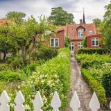 Denmark, Region of Southern Denmark, Aeroskobing, Flowers blooming in front yard of traditional Danish house